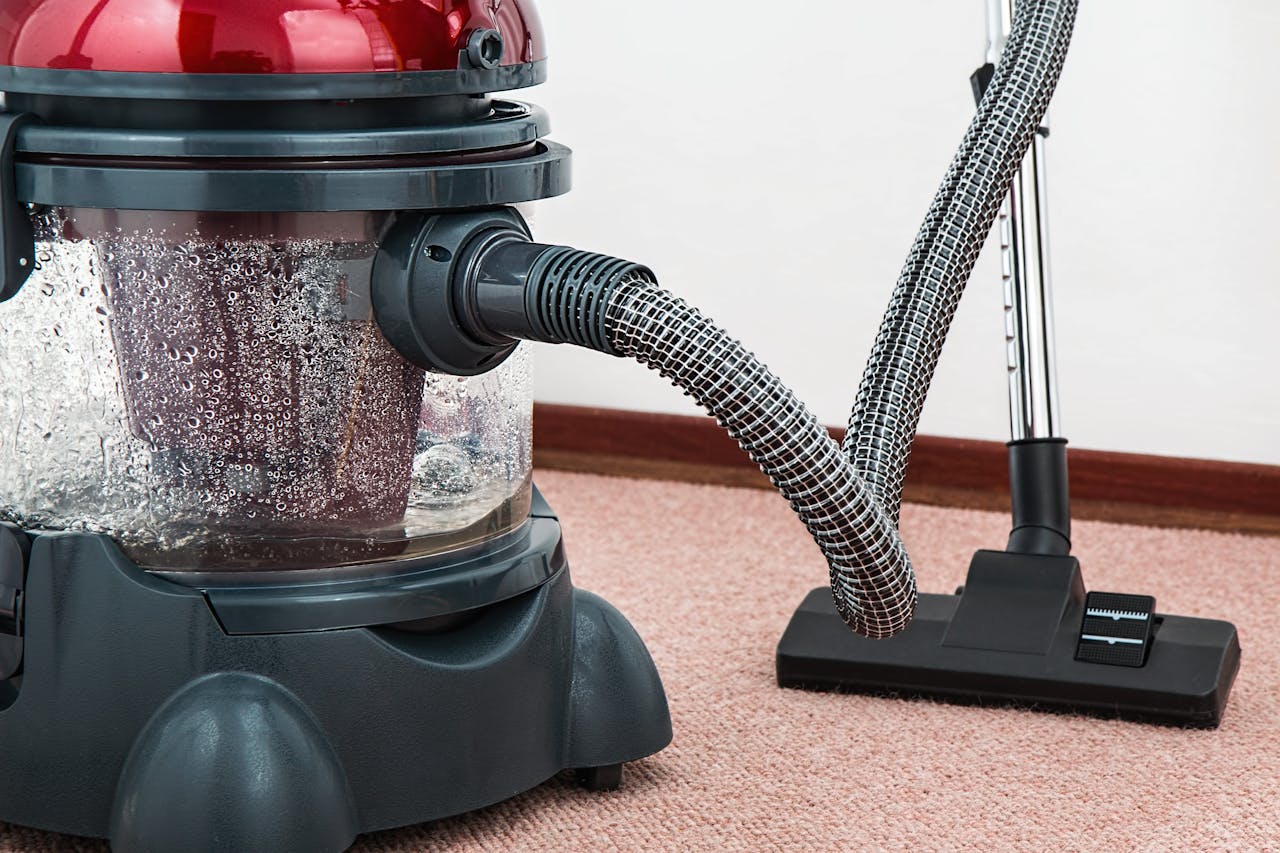 about-us Close-up of a modern vacuum cleaner with water filtration on carpet floor indoors.